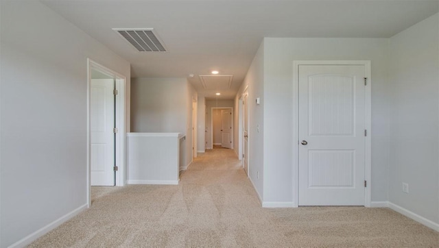 hallway featuring attic access, visible vents, baseboards, light colored carpet, and recessed lighting