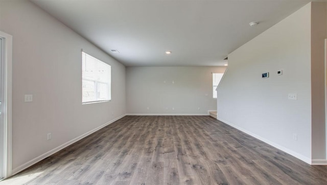 empty room with visible vents, baseboards, and wood finished floors