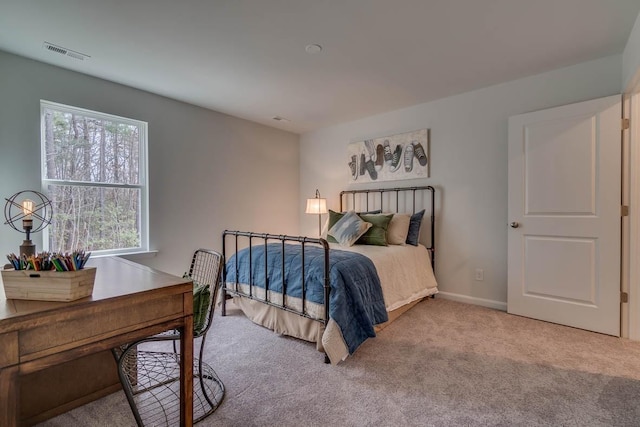 bedroom featuring baseboards, visible vents, and light colored carpet