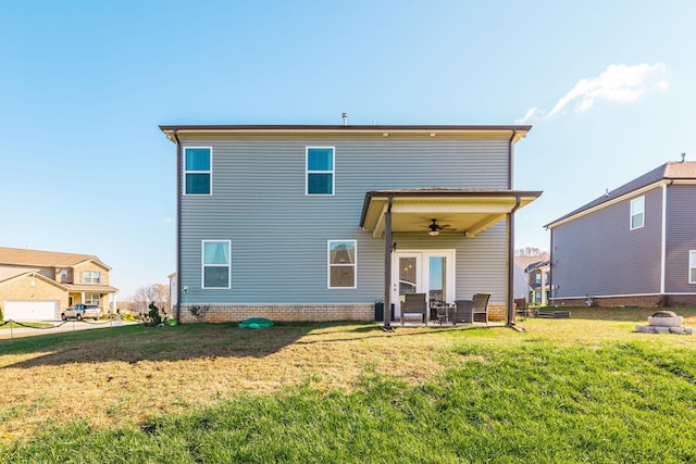 back of property featuring ceiling fan, a patio, and a lawn