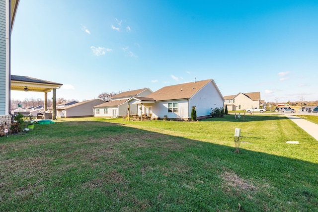 back of house featuring a residential view and a yard