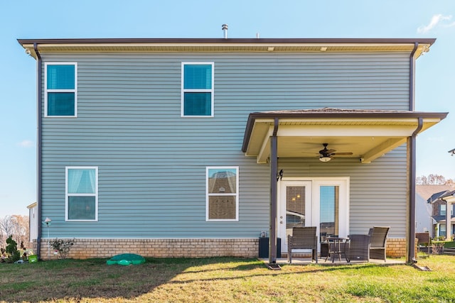 rear view of house featuring a ceiling fan, a patio, and a lawn