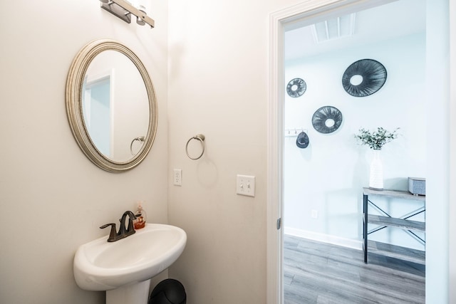 bathroom with baseboards, a sink, and wood finished floors