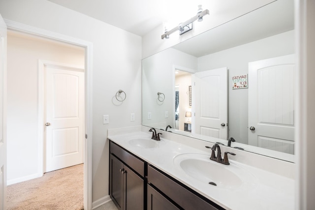 bathroom with double vanity, a sink, and baseboards