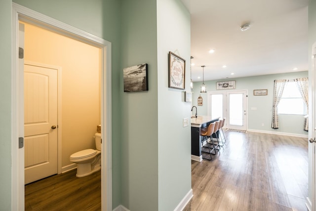 corridor featuring french doors, recessed lighting, wood finished floors, and baseboards