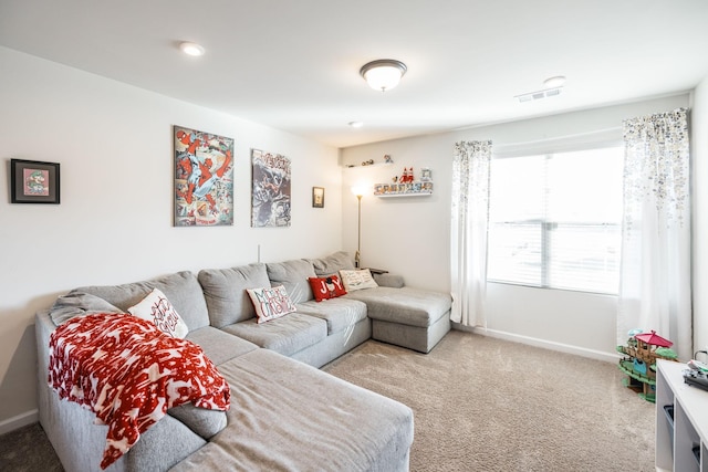 living area with baseboards, visible vents, and light colored carpet