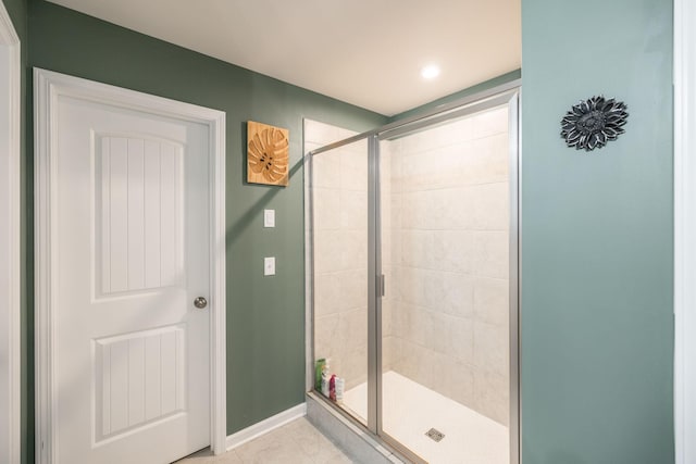 full bath with a shower stall, baseboards, and tile patterned flooring