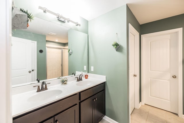 bathroom with double vanity, tile patterned flooring, a sink, and a shower stall