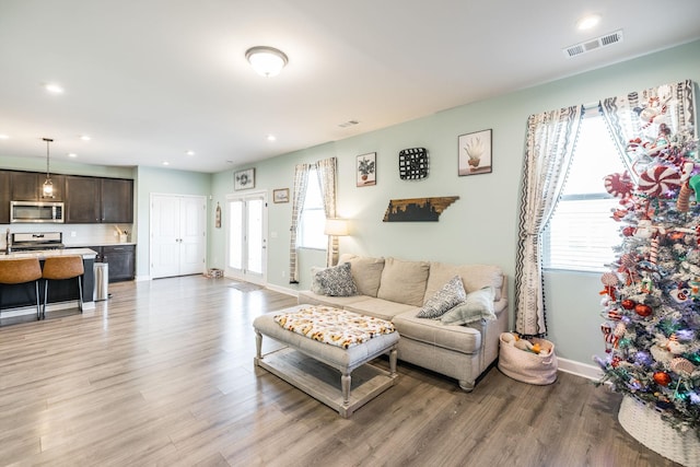 living area with baseboards, recessed lighting, visible vents, and light wood-style floors