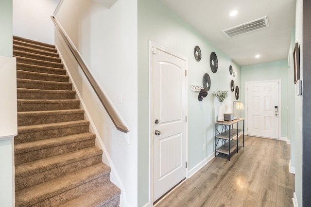 stairs featuring recessed lighting, wood finished floors, visible vents, and baseboards