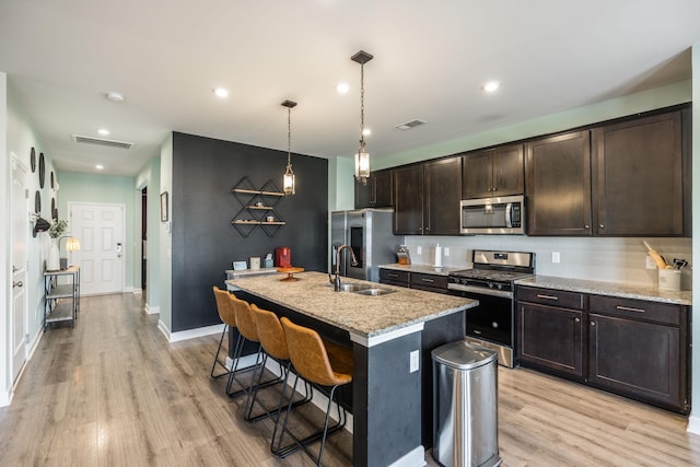 kitchen with dark brown cabinetry, visible vents, appliances with stainless steel finishes, and a sink