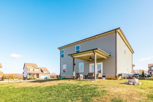 rear view of property featuring a patio area, a lawn, and a ceiling fan