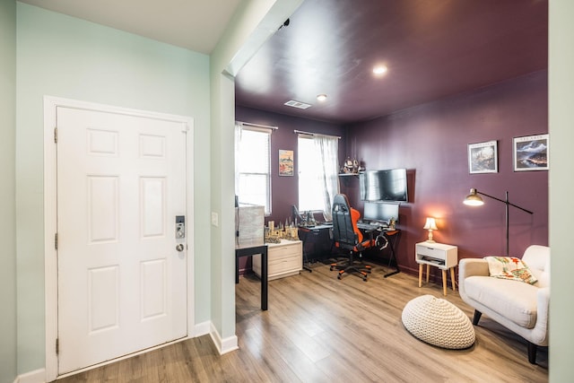 office space with baseboards, visible vents, and wood finished floors