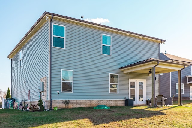 back of house with a lawn and ceiling fan