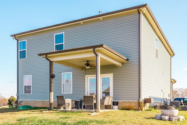 rear view of property with ceiling fan, a patio, and a yard