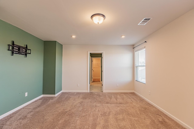 carpeted empty room with baseboards, visible vents, and recessed lighting