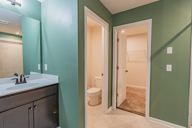 bathroom featuring tile patterned floors, vanity, toilet, and baseboards