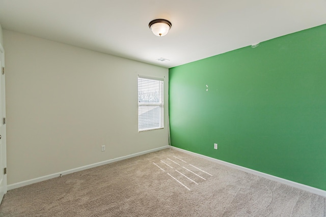 carpeted empty room featuring baseboards