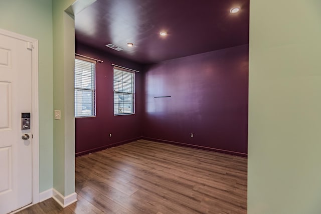 foyer featuring baseboards, visible vents, and wood finished floors