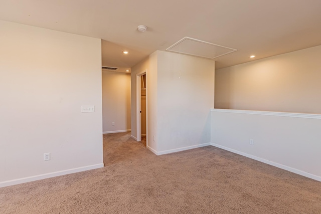 spare room with carpet, recessed lighting, attic access, and baseboards