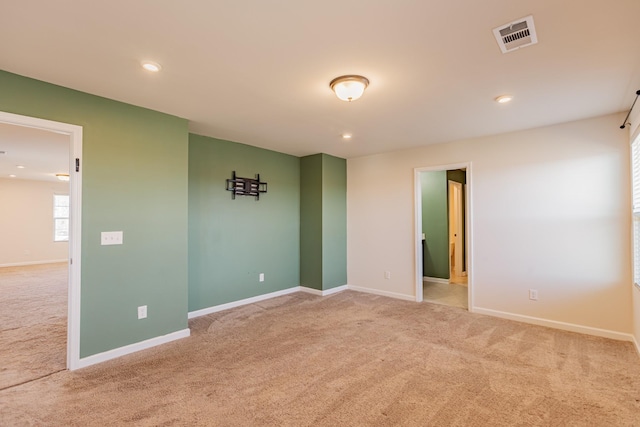 carpeted empty room featuring baseboards, visible vents, and recessed lighting