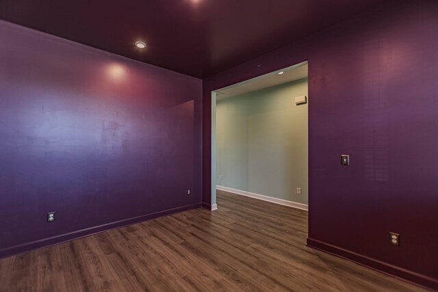 empty room featuring wood finished floors and baseboards