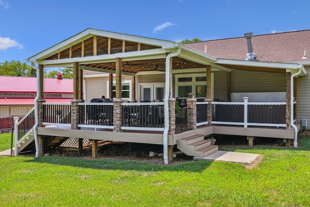 back of property featuring a lawn and a wooden deck