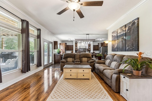 living room featuring ceiling fan, crown molding, baseboards, and wood finished floors