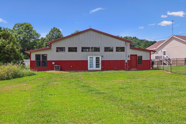 back of property featuring fence, central AC unit, and a lawn