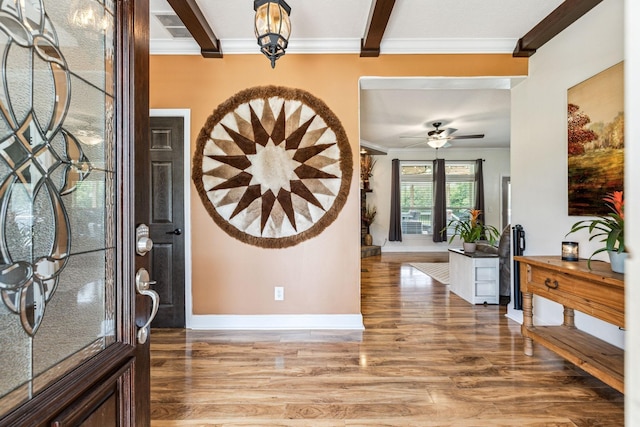 foyer featuring beam ceiling, crown molding, a ceiling fan, wood finished floors, and baseboards