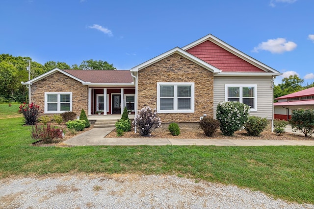 view of front of property featuring a porch, stone siding, and a front lawn