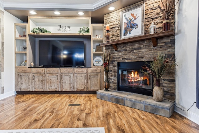 living room featuring recessed lighting, a fireplace, baseboards, ornamental molding, and light wood finished floors