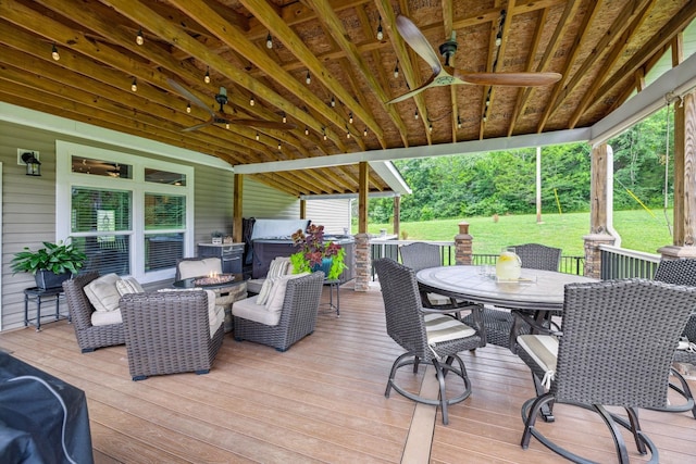 wooden terrace featuring ceiling fan, outdoor dining area, and an outdoor living space with a fire pit