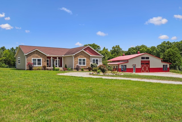 single story home with a barn, a front lawn, and an outbuilding