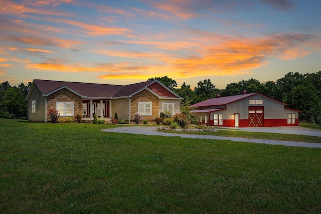 ranch-style house featuring an outbuilding, a garage, a barn, driveway, and a front yard