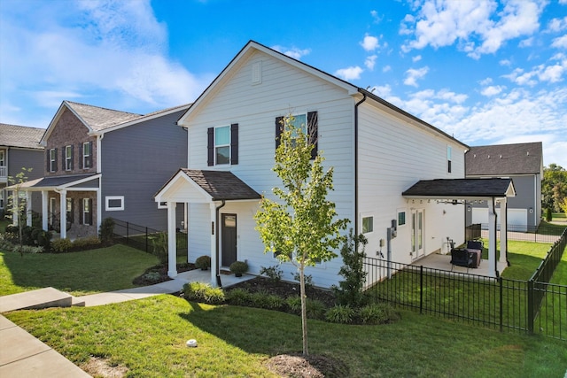 traditional home featuring a patio, a front lawn, and a fenced backyard