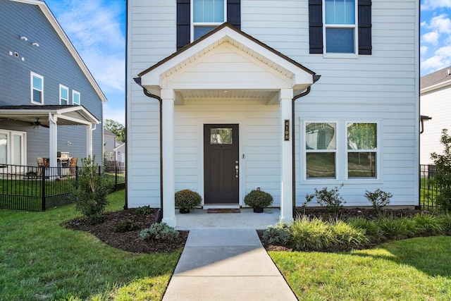 entrance to property with fence and a lawn