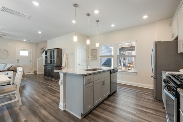 kitchen featuring decorative light fixtures, visible vents, appliances with stainless steel finishes, a kitchen island with sink, and a sink