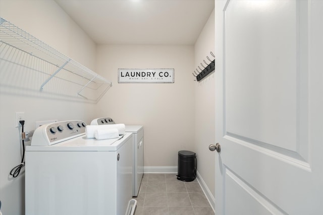 laundry area with light tile patterned floors, laundry area, independent washer and dryer, and baseboards