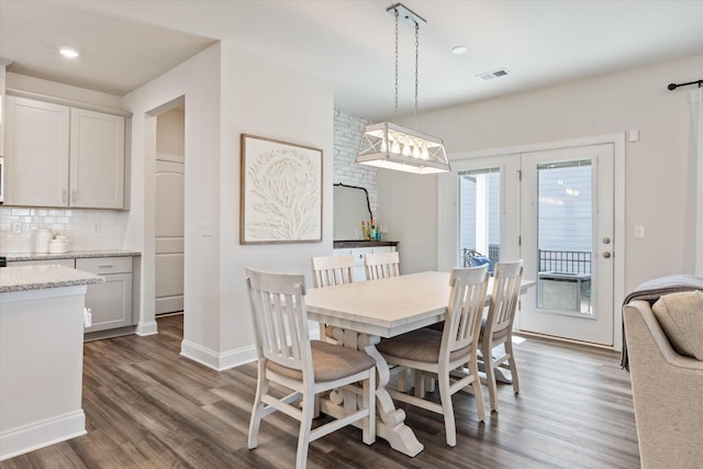 dining space featuring visible vents, dark wood finished floors, and baseboards