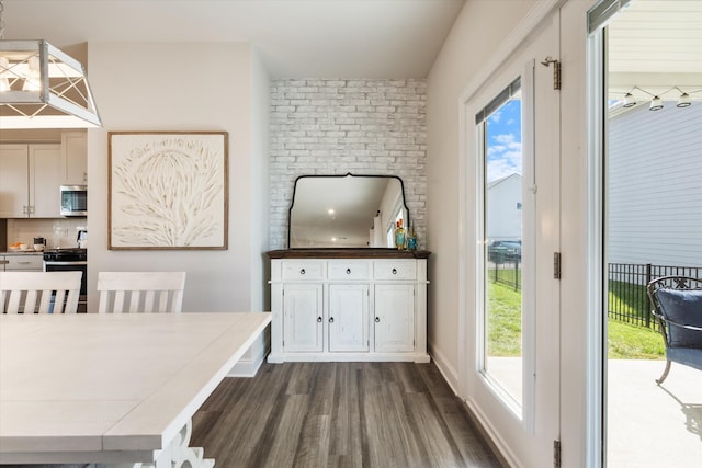 interior space featuring baseboards, dark wood-type flooring, and a healthy amount of sunlight