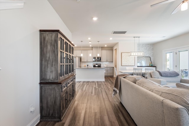 living room featuring baseboards, visible vents, ceiling fan, wood finished floors, and recessed lighting