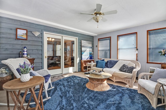 carpeted living area with ceiling fan, french doors, and a textured ceiling