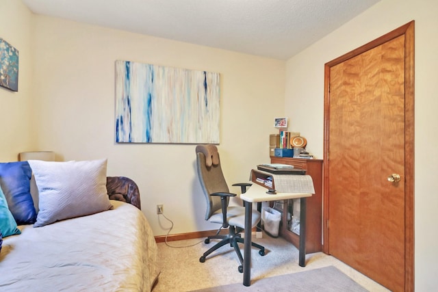 bedroom with light carpet, baseboards, and a textured ceiling