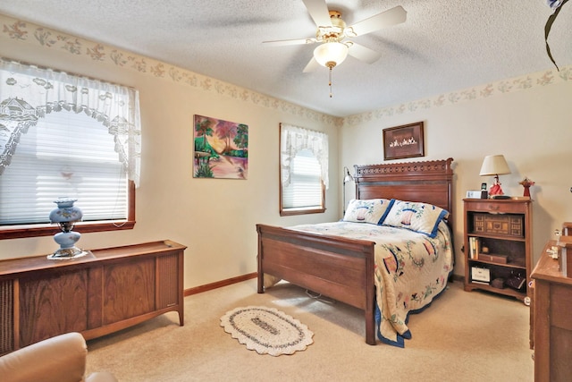 bedroom with light carpet, baseboards, and a textured ceiling