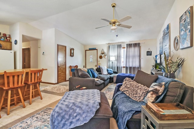 living room featuring ceiling fan, vaulted ceiling, baseboards, and light tile patterned floors