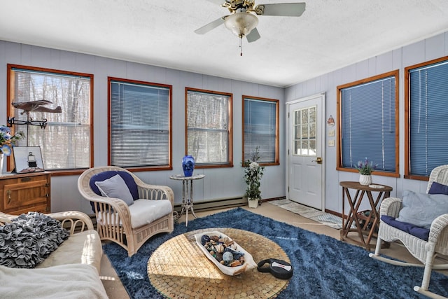 living area with a textured ceiling, baseboard heating, light carpet, and a ceiling fan