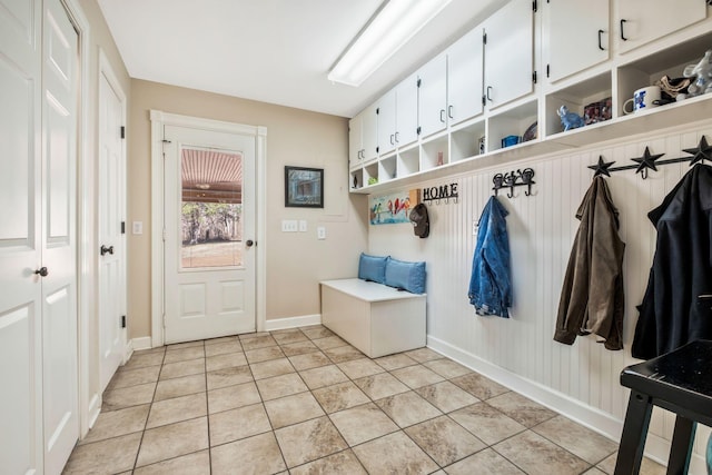 mudroom with light tile patterned floors and baseboards