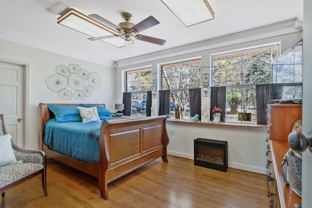 bedroom featuring multiple windows, ornamental molding, and wood finished floors