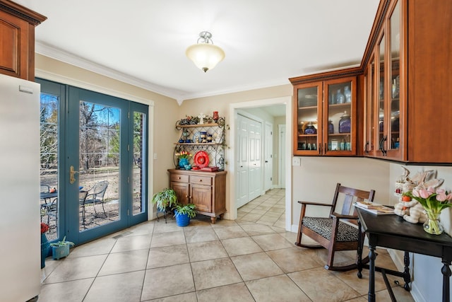 doorway to outside with ornamental molding, light tile patterned flooring, visible vents, and baseboards